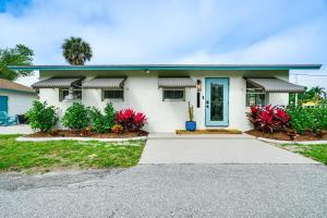 a white house with a blue door at Updated Punta Gorda Home about 1 Mi to Laishley Park! in Punta Gorda