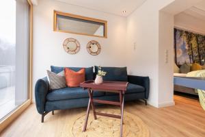 a living room with a blue couch and a table at Apart Feine Zeit - Apartment Waldele in Schönwies