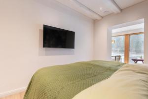 a bedroom with a bed and a television on the wall at Apart Feine Zeit - Apartment Waldele in Schönwies