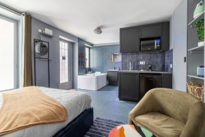 een slaapkamer met een bed en een keuken met een wastafel bij Opéra, Grand Boulevard 9ème, suite avec jacuzzi in Parijs