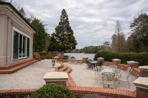 un patio con tavoli e sedie di fronte a una casa di Lakefront Retreat w/ Guest House a LaGrange