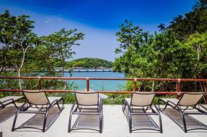 a group of chairs sitting on a deck overlooking the water at Nirú Ocean Suites by Binniguenda in Santa Maria Huatulco