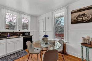 a kitchen with a glass table and chairs at The Victorian on South Park - Sleeps 6 in Buffalo