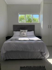 ein Schlafzimmer mit einem großen Bett mit einem Kissen darauf in der Unterkunft 77 on Percy in Johannesburg