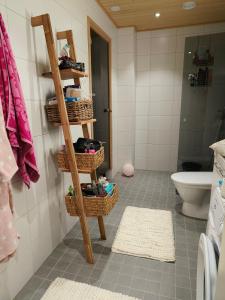 baño con estante con cestas y aseo en Villa Virpi, en Rovaniemi