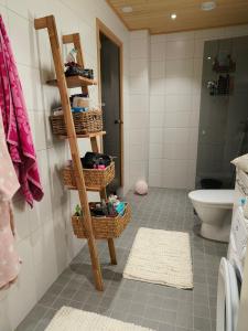 a bathroom with a shelf with baskets and a toilet at Villa Virpi in Rovaniemi