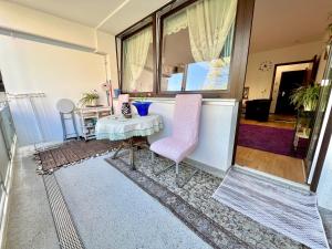 uma sala de estar com uma mesa e uma cadeira rosa em The Stylish&Cozy Apartment with 37㎡ in District 1 em Dusseldorf