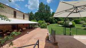 a patio with a large white umbrella next to a building at Country Hotel Poggiomanente in Umbertide
