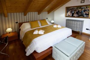 1 dormitorio con 1 cama blanca grande con 2 zapatos en Cozy Apartment with view - LAGHI E SENTIERI - 