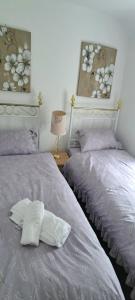 a bedroom with two beds and a picture of flowers at Wisteria Cottage an authentic and enchanting cottage experience in Aberdare