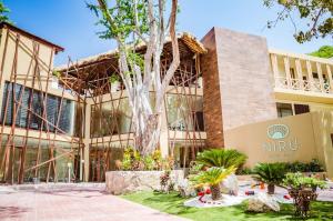 a building with a tree in front of it at Nirú Ocean Suites by Binniguenda in Santa Maria Huatulco