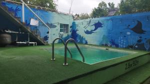 a swimming pool in front of a blue wall at Blue Magic Hostel in Cozumel