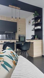 une chambre avec un lit et une cuisine avec des chaises dans l'établissement Le Studio, à La Louvière