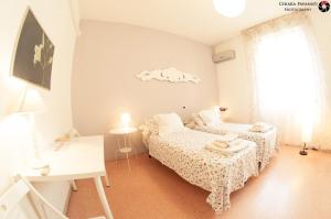 1 Schlafzimmer mit 2 Betten, einem Schreibtisch und einem Fenster in der Unterkunft Bed&Breakfast A Bologna in Bologna