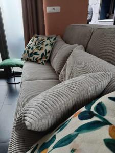 ein Sofa mit zwei Kissen darauf im Wohnzimmer in der Unterkunft Le Studio in La Louvière