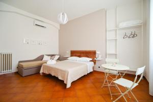 sypialnia z łóżkiem, stołem i kanapą w obiekcie B&B il Faro w mieście Salerno