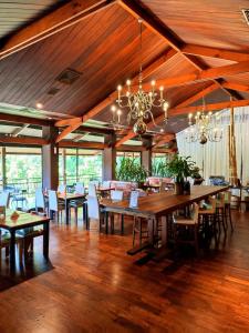 uma grande sala de jantar com mesas e cadeiras de madeira em Hotel Raices Esturion em Puerto Iguazú