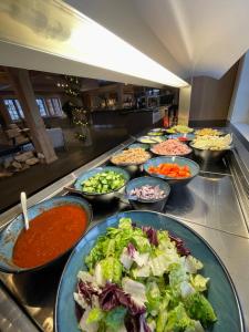 una línea de buffet con cuencos de diferentes tipos de comida en Oppdalsporten Motell, en Oppdal