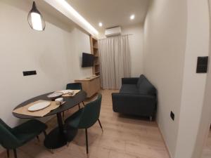 a living room with a table and chairs and a couch at Real City Karagiorgi in Athens