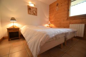 a bedroom with a large bed and a window at Résidence Hameau Des Marmottes - 4 Pièces pour 6 Personnes 514 in Les Menuires