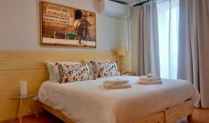 um quarto com uma cama com toalhas em THE HOLY COW - Hostel & Suites em Ponta Delgada