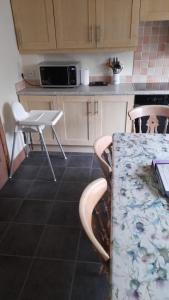 una cucina con tavolo, due sedie e bancone di Holiday House Kinveachy ad Aviemore