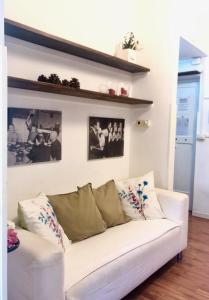 een witte bank in een woonkamer met foto's aan de muur bij Casa della salita in Rome