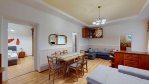 a dining room and living room with a table and chairs at Herczeg Apartment in Miskolctapolca