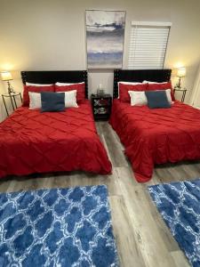 two beds in a room with red and blue rugs at Sunset Dream Cottage in Los Angeles
