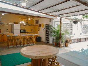 a room with a wooden table and a kitchen at Casa al pie de la playa con Aire acondicionado y BBQ in Playas