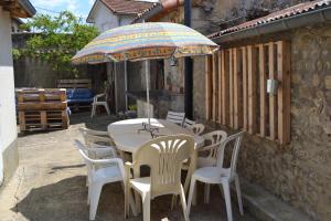 uma mesa e cadeiras com um guarda-sol num pátio em Gîte familial chaleureux à la campagne 20mn FUTUROSCOPE em Savigny-Lévescault