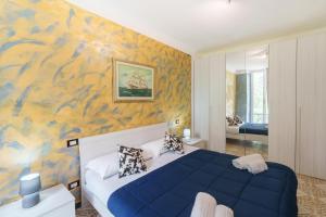 a bedroom with a blue bed and a yellow wall at Willy's apartment in Manarola