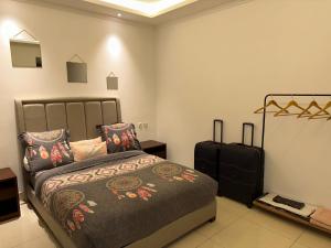 a bedroom with a bed and a suitcase at SYN - Mpila in Brazzaville