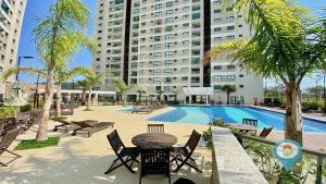 a swimming pool with a table and chairs and a building at ITA506T1 Beto Carrero e Praia ótima localização! in Piçarras