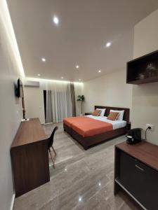 a hotel room with a bed and a desk and a computer at Vasiliki Apartments in Plataniás