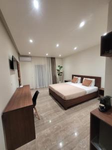 a hotel room with a bed and a desk at Vasiliki Apartments in Plataniás +11 photos