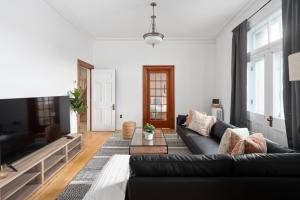 een woonkamer met een bank en een tv bij Penthouse / Sunset Private Terrace, 6Bdrs-13Guests in Montreal