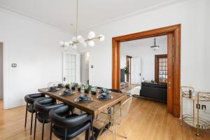 uma sala de jantar com uma mesa de madeira e cadeiras pretas em Penthouse / Sunset Private Terrace, 6Bdrs-13Guests em Montreal