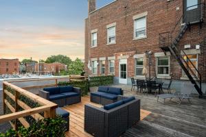 a rooftop deck with furniture and a brick building at Penthouse / Sunset Private Terrace, 6Bdrs-13Guests in Montreal