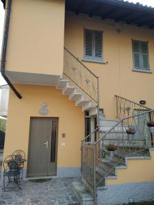 una casa amarilla con escaleras y una puerta en Corte del Camparo, en Arcore