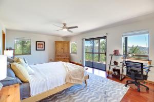 a bedroom with a bed and a desk and windows at Idyllic Kelseyville Home with 2 Decks and Views! in Kelseyville