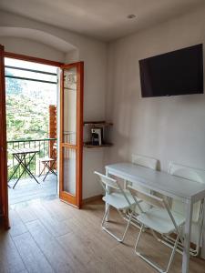 a dining room with a table and chairs and a balcony at Belvedere Affittacamere in Corniglia