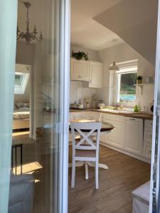 a kitchen with a white table and a white chair at Noclegi Panorama in Ustrzyki Dolne