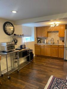 a kitchen with wooden cabinets and a clock on the wall at Del Boca Vista in Owatonna