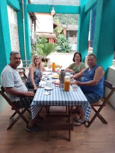 a group of people sitting around a table at Canto do mar in Paraty