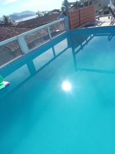 an empty swimming pool with a fence and blue water at Canto do mar in Paraty