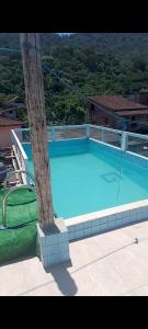 a large blue swimming pool next to a pole at Canto do mar in Paraty