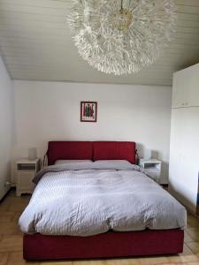 Un dormitorio con una cama grande y una lámpara de araña. en Lago Maggiore - Loft Apartment, en Ispra