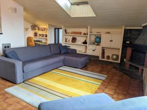 sala de estar con sofá azul y chimenea en Lago Maggiore - Loft Apartment en Ispra
