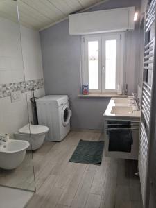uma casa de banho com um lavatório e uma máquina de lavar roupa em Lago Maggiore - Loft Apartment em Ispra